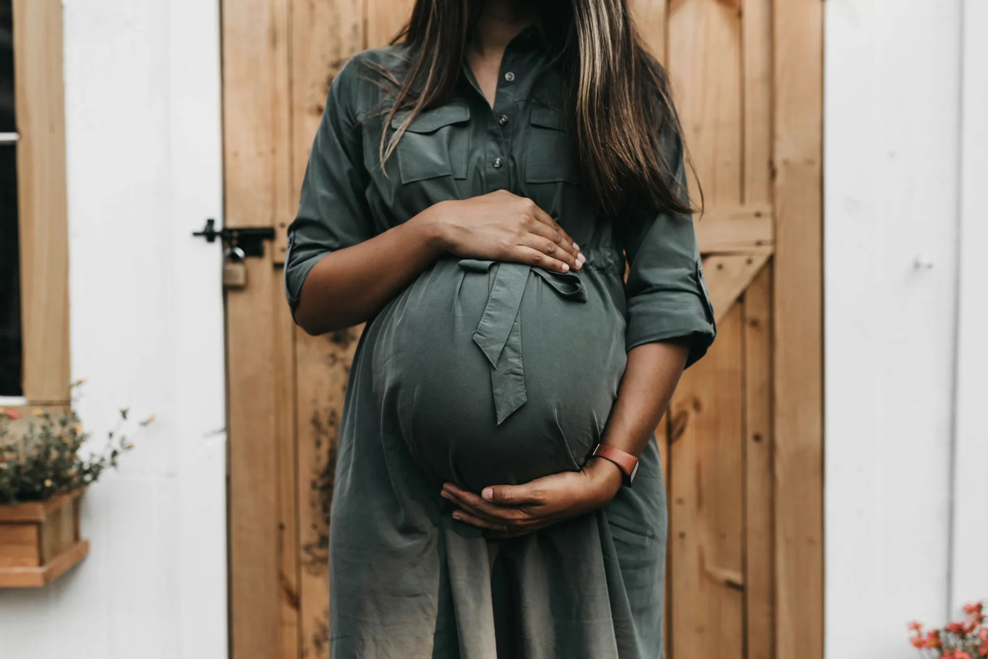 Oceanside chiropractor offering gentle pregnancy chiropractic care to an expecting mother cradling her baby bump