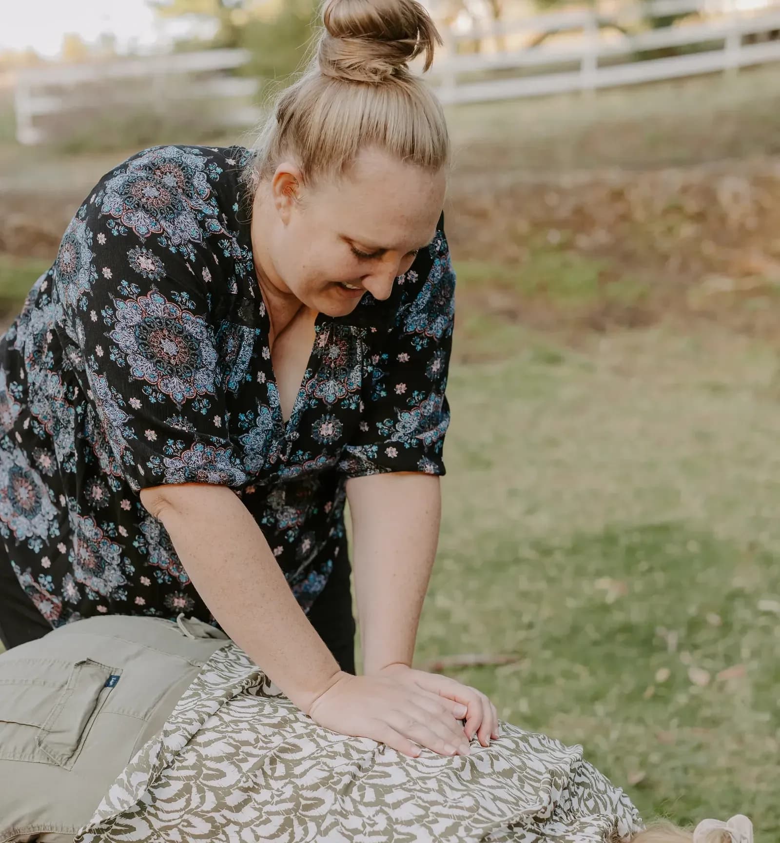 Dr. Caitlin Walker gently adjusting the upper back of a patient lying face down in Oceanside