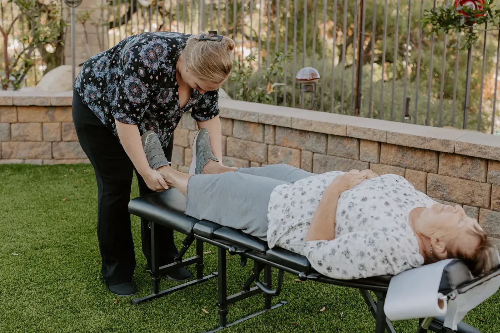 Dr. Caitlin Walker holding a patient's ankles to check leg length and pelvic balance in Oceanside