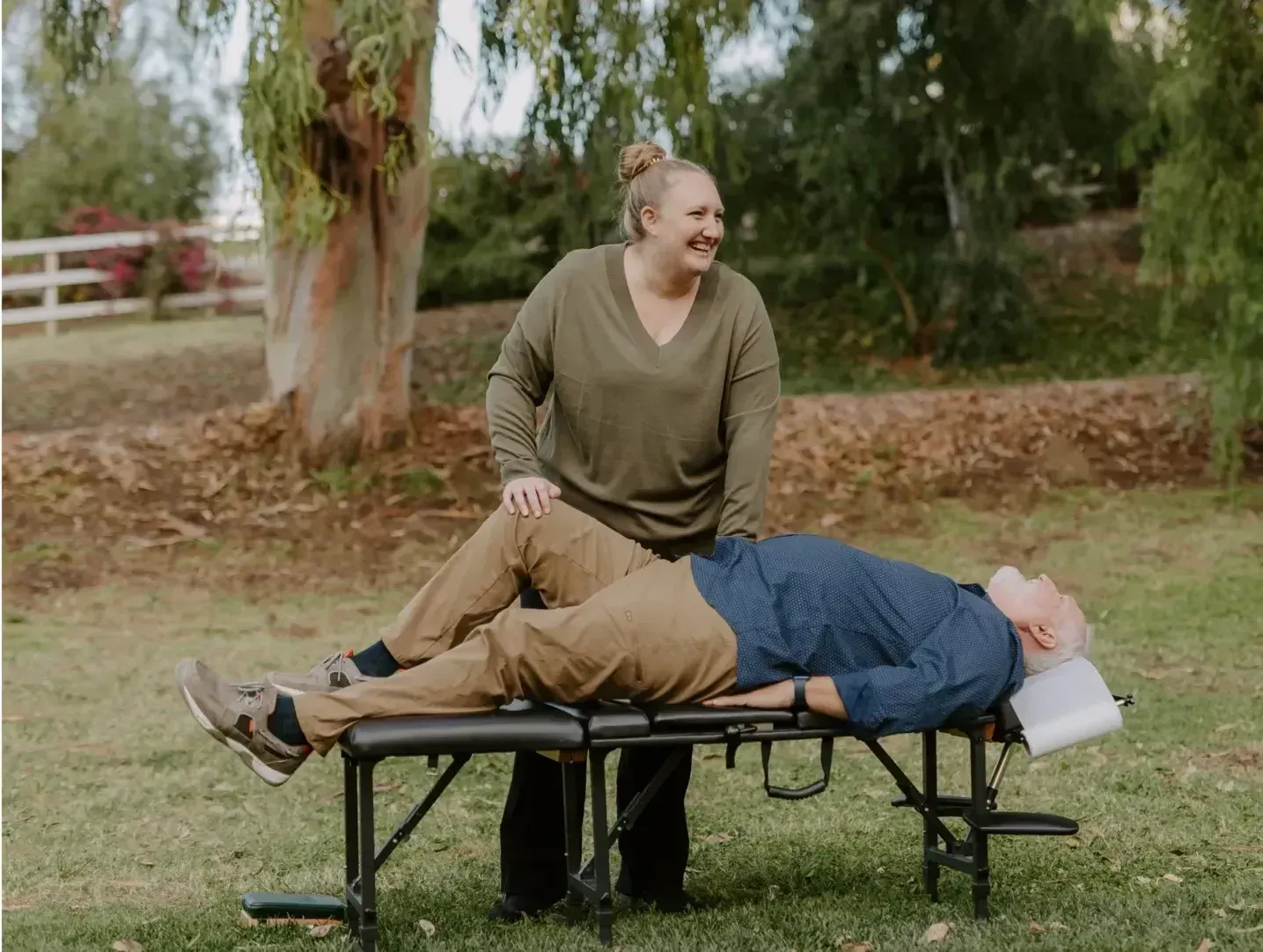 Oceanside chiropractor Dr. Caitlin Walker caring for a patient lying on an outdoor adjusting table
